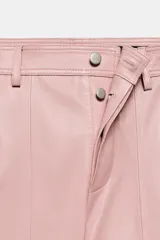 Pantalón de tiro medio de ZARA Woman Collection, confeccionado 100% en piel de color rosado. Cuenta con cintura con trabillas, bolsillos laterales, pespuntes marcados a tono y cierre frontal con cremallera y botón oculto.