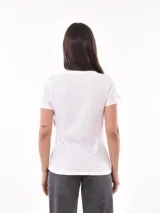 Remera negra de algodón con estampado frontal de la palabra "MERCI" en letras delineadas con colores del arcoíris.