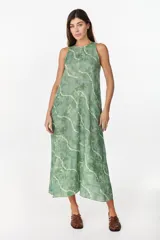 Vestido midi verde de lino italiano, con diseño sin mangas, cuello redondo y estampado de líneas onduladas punteadas. Cuenta con bolsillos laterales.