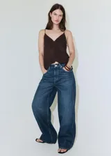 Jeans de mezclilla en color azul, con diseño de pierna ancha y tiro medio, con bolsillos laterales y traseros tradicionales.