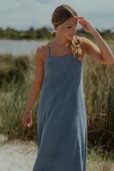 Vestido midi de denim color celeste, con escote recto, breteles finos y corte evasé amplio.