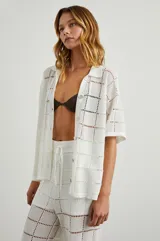 Camisa blanca de manga corta con botones en el frente, corte cuadrado y calce cómodo.