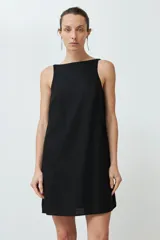 Vestido corto negro de lino, corte recto, sin mangas y con bolsillos laterales.