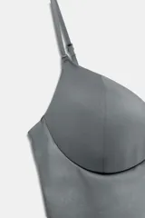 Top ajustado de poliamida en color negro, con diseño tipo corset, escote corazón y tirantes finos ajustables.