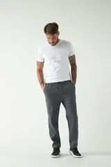 Pantalón de felpa gris para hombre con logo estampado, cintura ajustable y bolsillos.