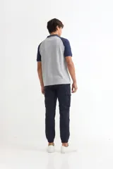Pantalón tipo jogger cargo color verde militar, con bolsillos laterales con solapa, cintura elástica con cordón ajustable y puños elásticos en los tobillos.