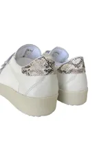 Zapatillas blancas de cuero con detalles en cuero gamuzado color beige en la puntera y ajuste con velcro. Presenta detalle de cuero con estampado reptil en el talón.