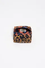 Neceser de estructura blanda con estampado animal print (leopardo/manchas) en tonos marrones y negros, con detalles en colores vibrantes (azul, rojo) en la parte superior. Cuenta con cierre de cremallera y logo metálico de Bimba y Lola.