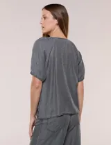 Blusa de calce relajado de lyocell en tono azul denim, con cuello a la base y cierre frontal de botones metálicos. Tiene mangas cortas abullonadas con puños elásticos.