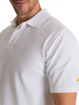 Remera tipo polo de manga corta color blanco, con cuello de punto acanalado y tapeta con botones. Presenta el logo de la marca CAT bordado en el pecho y un detalle de triángulo amarillo en la manga.
