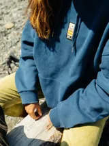 Canguro azul marino con capucha, bolsillo tipo canguro y logo estampado en el pecho.