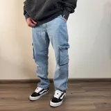 Pantalón tipo cargo de jean en color azul claro, con corte recto y bolsillos laterales con solapa en los muslos.
