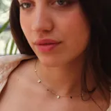 Cadena fina dorada con dijes pequeños rectangulares, de cristales claros.