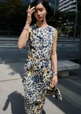 Top corto sin mangas, con cuello redondo y diseño recto, confeccionado en algodón con estampado de leopardo en tonos beige y negro/azul oscuro.