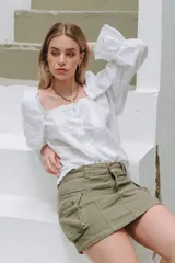 Minifalda cargo de denim azul oscuro con costuras pespuntadas y grandes bolsillos laterales con solapa y botones a presión.