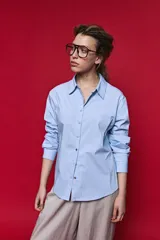 Camisa de manga larga color blanco, con cuello clásico y cierre frontal de botones de nácar. Presenta un corte cómodo y versátil.