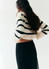 Chaleco oversize de punto con diseño a rayas horizontales en color crudo y negro, cuello redondo y mangas sisa con amplios ribetes elásticos.
