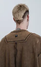 Buzo de cuello redondo con calce oversize y hombros caídos. Confeccionado en algodón gamuzado pesado con un proceso de lavado efecto óxido que genera un tono irregular. Presenta costuras expuestas a contratono y detalles de roturas en cuello, puños y ruedo, logrando una estética desgastada.