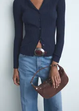 Pantalón jeans de tiro alto y corte wide leg, confeccionado en tejido de algodón con elasticidad. Presenta diseño de cinco bolsillos, cierre frontal con botón y cremallera, y trabillas para cinturón.