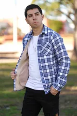 Sobrecamisa de hombre a cuadros en tonos celeste, blanco y azul marino, con forro interno de corderito, bolsillos en el pecho y cierre frontal con botones.
