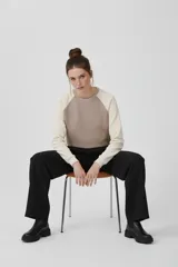 Buzo de algodón con diseño bicolor: cuerpo color beige y mangas raglán color crema. Cuello redondo y corte holgado.