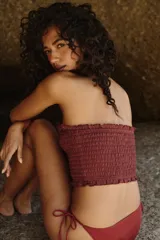 Top strapless color bordó confeccionado en punto smock, con diseño elástico y ribetes con volados sutiles en el escote y en el bajo.