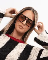 Lentes de sol con armazón de policarbonato negro y cristales tintados en tono ámbar, con diseño de estilo retro y protección UV400.