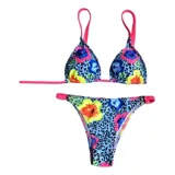 Conjunto de bikini United Uy modelo Mili, con estampado colorido de flores sobre fondo celeste con patrón de leopardo. El corpiño es de diseño triangular con tirantes fucsias y la bombacha es de corte tanga con detalles ajustables en los laterales.