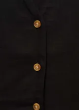 Vestido midi de tejido fluido mezcla de lino y viscosa, color negro. Presenta cuello en pico, mangas cortas con dobladillo y cierre frontal completo con botones. Diseño evasé con corte entallado en la cintura.