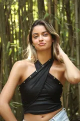 Top negro de tejido acanalado, con diseño cruzado en el frente y tachas doradas.