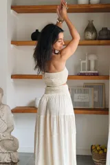 Conjunto compuesto por un top fruncido strapless de algodón con detalle de lurex y una falda larga fluida de talle alto con volantes y cintura fruncida.
