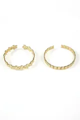 Set de dos brazaletes dorados con diseño calado. Uno con diseño de flores y otro con diseño geométrico.