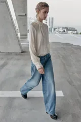 Jeans de tiro alto, color celeste claro con efecto desgastado y lavado. Modelo de corte holgado (loose baggy) con cierre frontal de botones metálicos y cinco bolsillos.