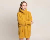 Sweater mostaza de lana merino con cuello alto y bolsillos delanteros. Diseño holgado y atemporal.