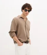 Camisa de hombre color marrón, confeccionada en algodón texturizado con patrón melange. Presenta cuello inglés, manga larga y abotonado frontal.