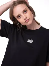 Remera de algodón color negro con cuello redondo y mangas cortas. Presenta un pequeño gráfico estampado en el lado izquierdo del pecho y una etiqueta con el logo de la marca en el dobladillo.