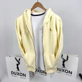 Campera con capucha de algodón grueso color amarillo patito, con cierre frontal y bolsillos tipo canguro. Presenta un pequeño logo bordado en el pecho.