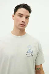 Remera de manga corta color beige, con corte regular y pequeño diseño bordado en el pecho.