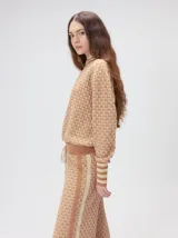 Sweater de tejido de punto jacquard con diseño geométrico, cuello redondo y puños acanalados en contraste de color verde y beige.