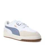 Championes urbanos Puma modelo Shuffle Downtown OG, de diseño retro con base blanca, detalles en gris azulado y puntera de gamuza en tono beige. Cuenta con suela de goma color caramelo y logo de la marca en dorado.