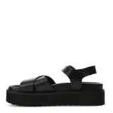 Sandalias Miss Carol modelo Marbela, de color negro con plataforma flatform recta y suela con relieve texturizado. Capellada con tiras anchas cruzadas sobre el empeine y correa trasera con hebilla metálica dorada para ajuste seguro.