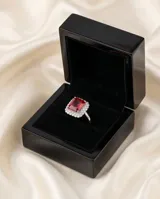 Anillo de plata 925 con piedra central de raíz de rubí en corte rectangular, rodeada por un halo de circonias brillantes.