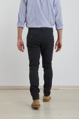 Pantalón de vestir verde oliva, de corte slim fit, sin pinzas, con bolsillos laterales y traseros. Se ajusta a la cintura con cinturón de cuero marrón.
