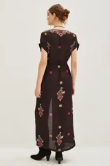 Vestido largo de viscosa en color negro con estampado étnico multicolor, escote en V profundo, mangas cortas y ajuste en la cintura con cordón. Presenta una abertura frontal central.