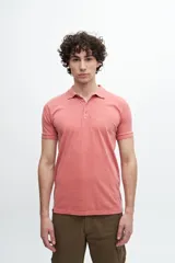 Remera polo color salmón de corte clásico, con cuello y mangas acanaladas, y logo bordado en el pecho.