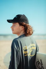 Remerón gris oscuro con efecto wash, manga corta y calce oversize. Presenta estampa en la espalda con tipografía amarilla y diseño alusivo al surf.