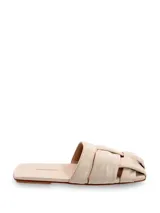 Mule chato de cuero color crema, con capellada trenzada y plantilla forrada. Modelo de punta cuadrada.