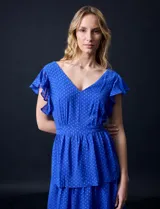 Vestido blanco de gasa con capas, marca Julia Jordan. Escote en V, manga corta con volados, corte en cintura y abertura central en espalda con cierre invisible.