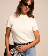Blusa de punto texturizado color blanco, con cuello alto y mangas cortas, de la marca Cortelle.