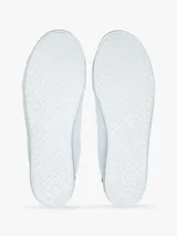 Zapatillas urbanas Tommy Hilfiger de corte bajo, color blanco con detalle azul en el talón. Tienen diseño con cordones, suela de goma blanca y pequeño logo bordado en el lateral.
